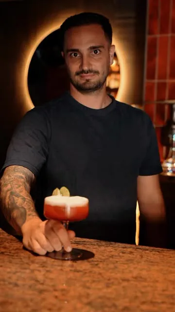 Cóctel rojo servido en la barra de NOOR