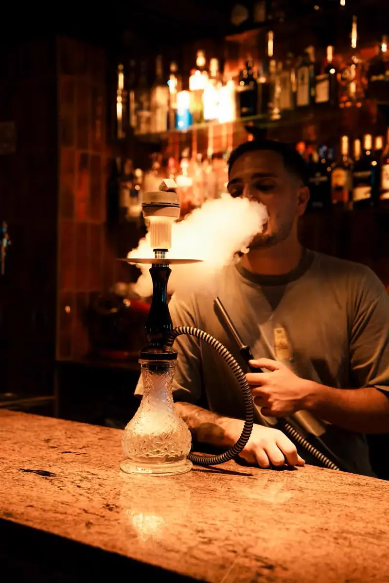 Cliente disfrutando de una cachimba en la barra de NOOR Lounge